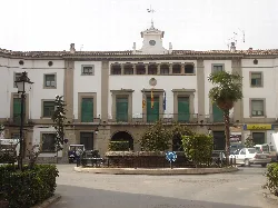 Town hall building with flags and fountain in the square.