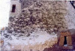 Reste der Burgmauer an einer Hauswand.