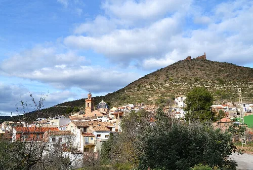 Vista de Azuébar con iglesia y castillo en la colina, en Castellón.