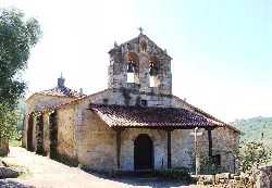 Stone church with bell tower and red tiled roof in Las Casas del Conde.