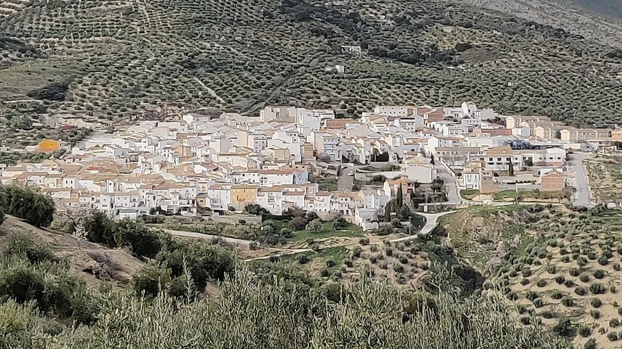 Vista panorámica de un pueblo con casas blancas y colinas con vegetación.