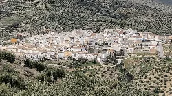 Vista panorámica de un pueblo con casas blancas y colinas con vegetación.