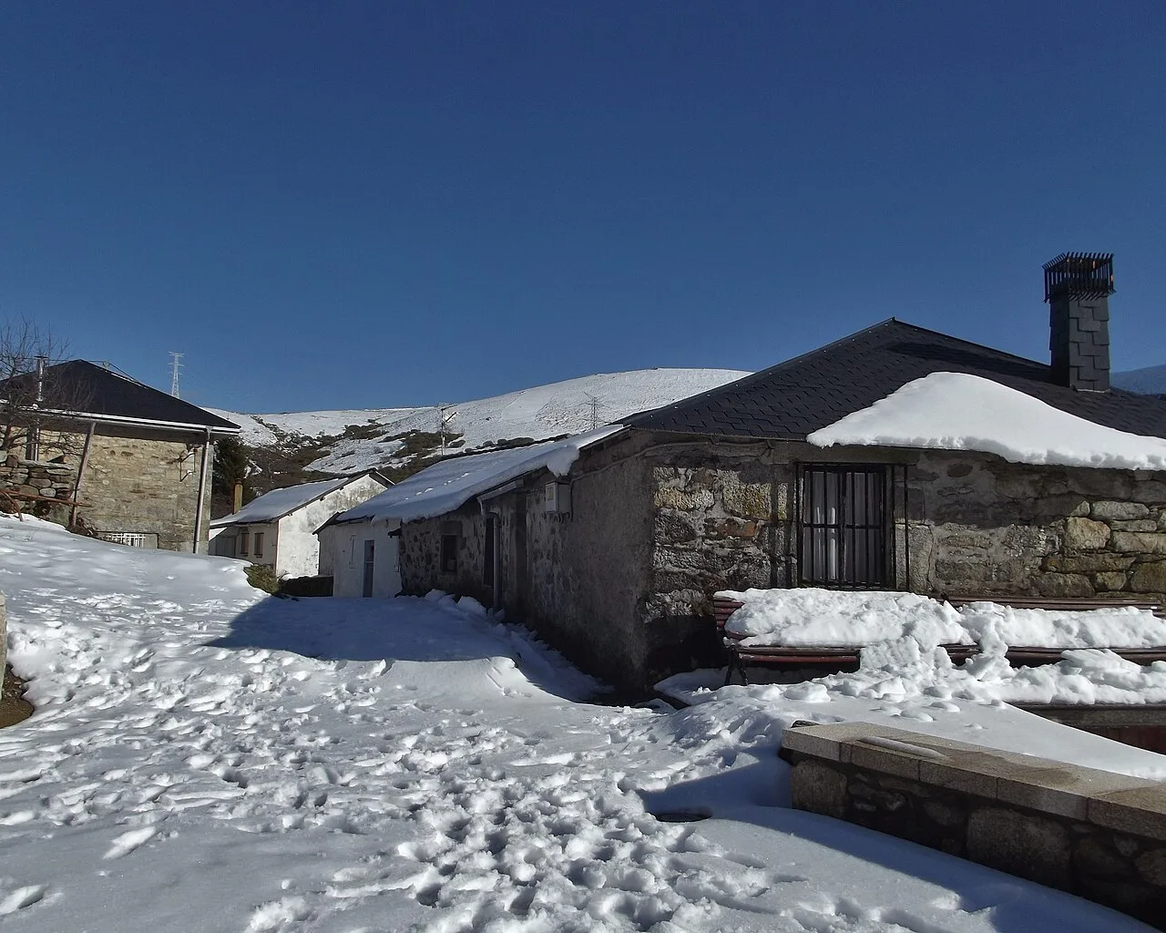 Stone houses covered in snow on a sunny day in Padornelo, Zamora.