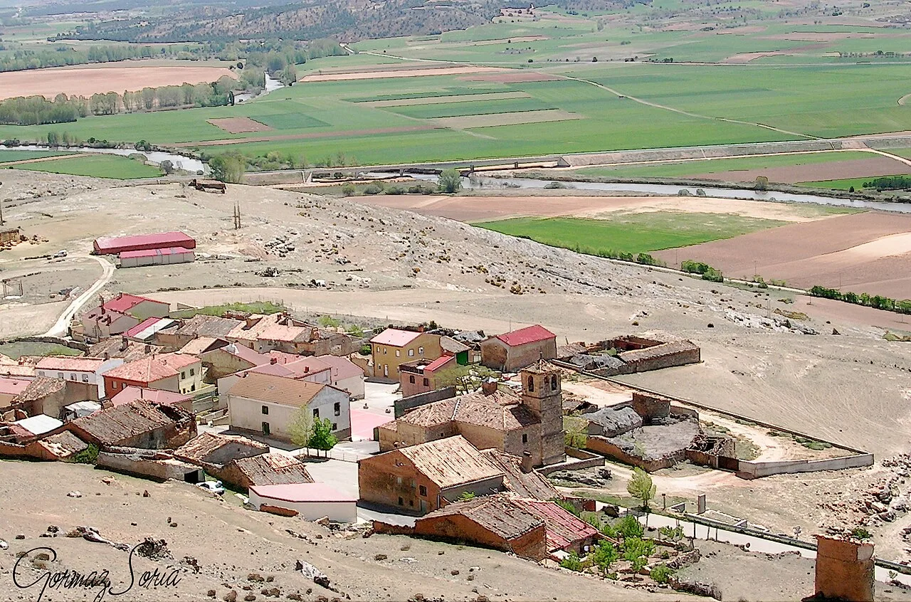 Vista de casas y iglesia en Gormaz, Soria, en un paisaje rural.