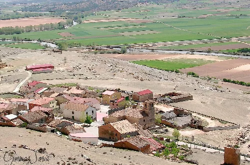 Häuser und Kirche in Gormaz, Soria, in einer ländlichen Landschaft.