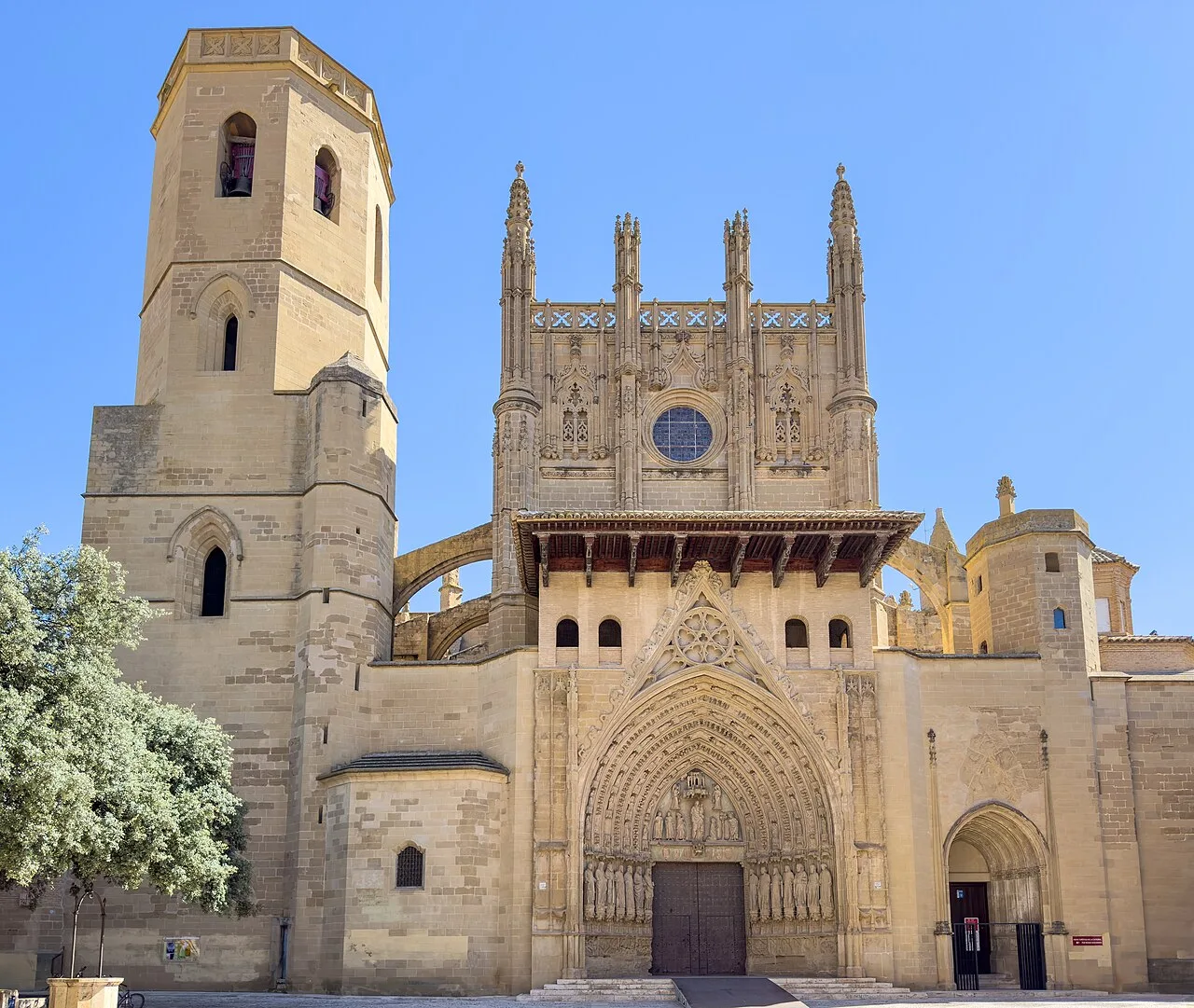 Außenfassade der Kathedrale von Huesca mit gotischer Tür und Türmen.