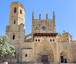 Facade of Huesca Cathedral with Gothic door and towers.