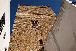 Guzmanes Tower with brick walls and small windows.