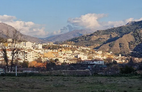 Landschaft von Cenes de la Vega mit Häusern und Bergen im Hintergrund.