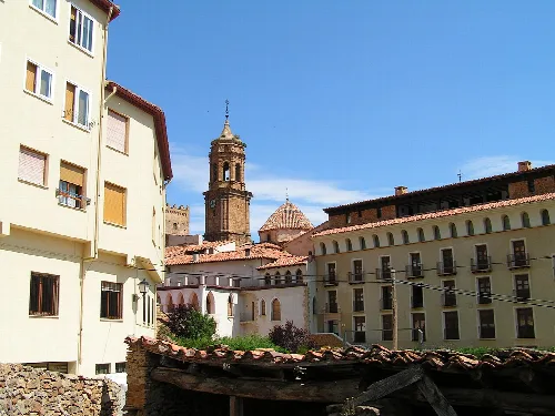 Straßen und Kirche in La Iglesuela del Cid, Teruel, mit alten Gebäuden und Glockenturm.