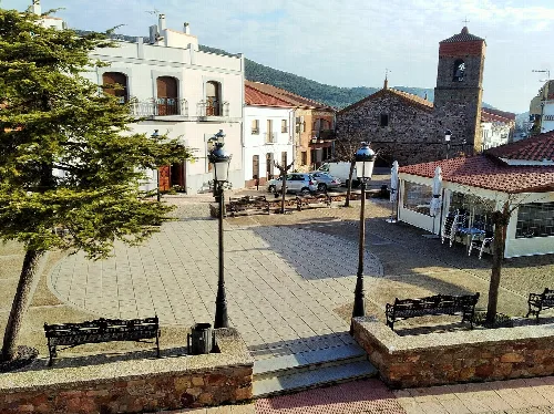 Platz mit Bänken, Laternen, Kirche und Rathaus in Garbayuela.