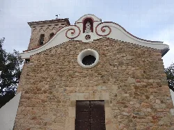 Kirchenfassade mit Steinmauer und Glockenturm in Lloret de Mar.