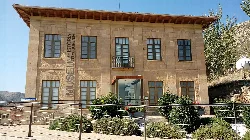 Two-story building with windows and a sign at the entrance.