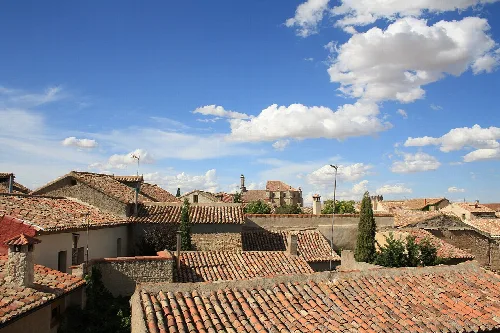 Tejados de Urueña con cielo azul y nubes.
