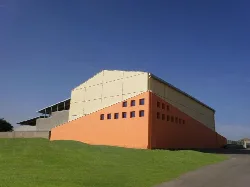 Gebäude der Sportanlagen mit beigen und orangefarbenen Wänden und kleinen Fenstern.