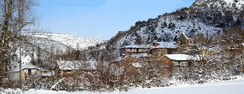 Panoramic view of houses and trees in a snowy valley.
