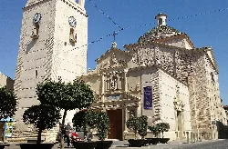 Church facade with trees and clock on the tower.