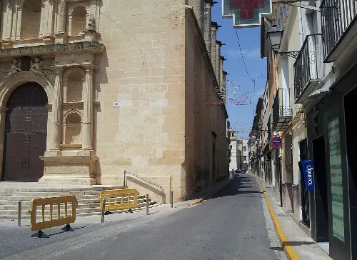Enge Straße mit alten Gebäuden und einer Kirche in Benigánim.