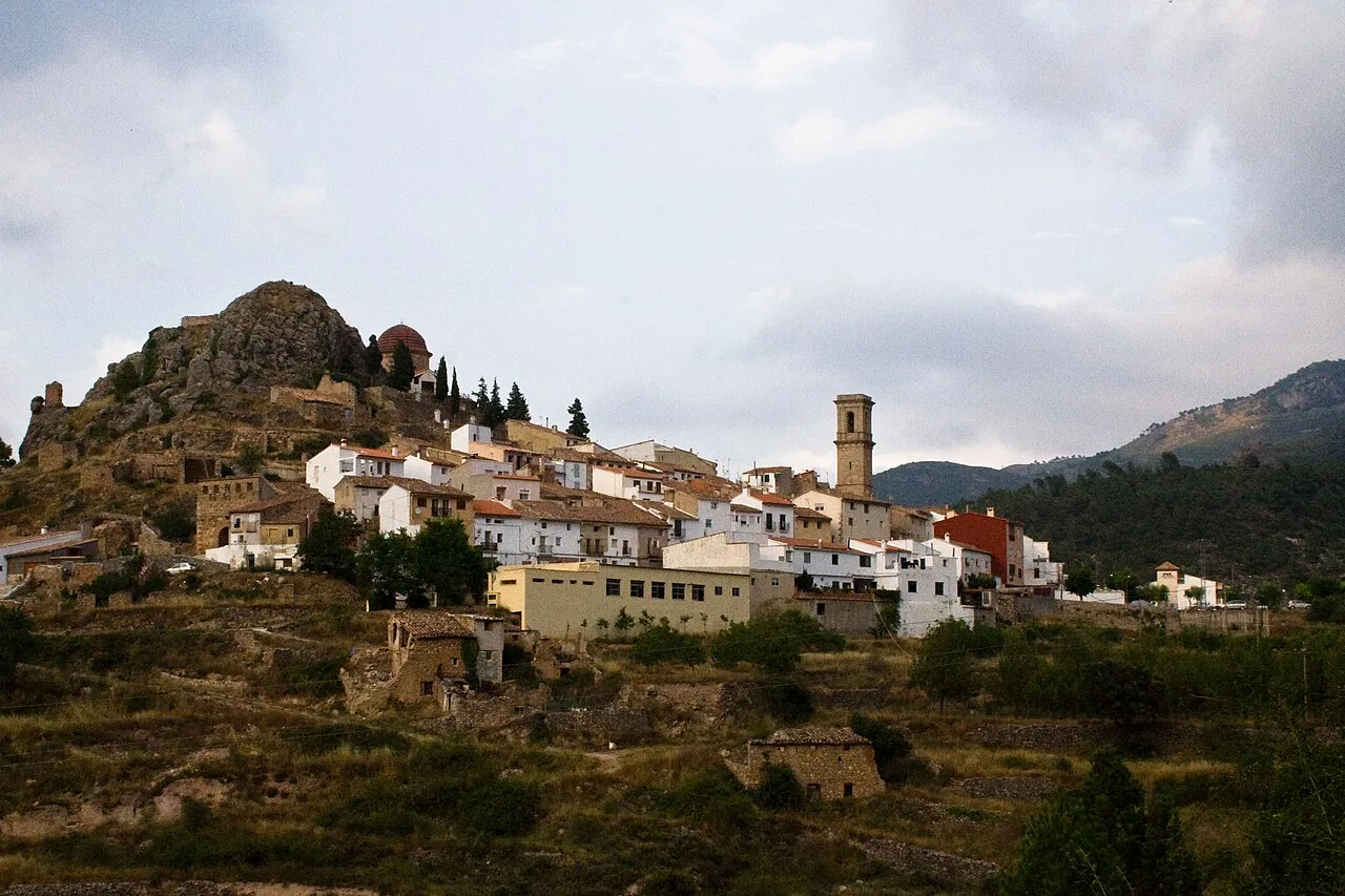 Vista de un pueblo en una ladera con casas blancas y una iglesia en el centro.