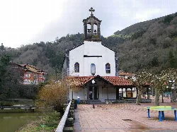 White church with bell tower and cross in El Regato, Barakaldo.