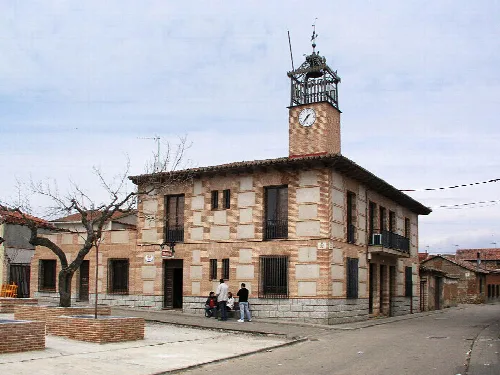 Town hall building with clock and tower on the corner.