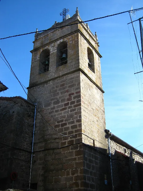 Stone tower with bells and cross at the top.