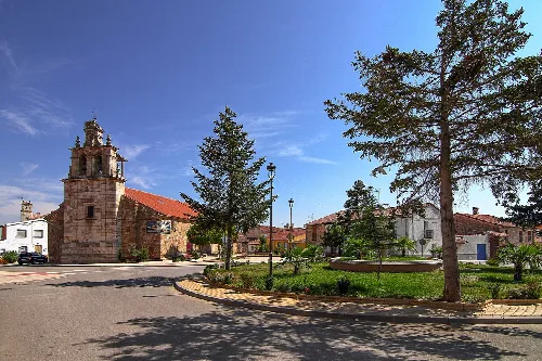 Main square with church and trees in Calvarrasa de Arriba.