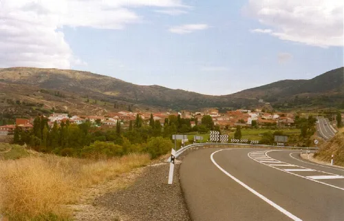 Landschaft mit Häusern, Bergen und einer Straßenkurve in Casas del Puerto.