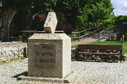 Denkmal in Buendía mit Skulptur und Gedenktafel in einem Park.