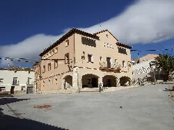Town hall building with arches on the ground floor and light-colored facade.