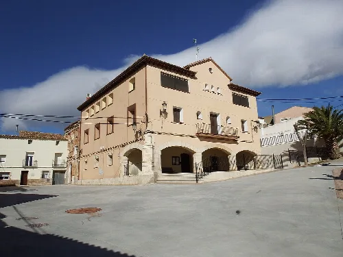 Town hall building with arches on the ground floor and light-colored facade.