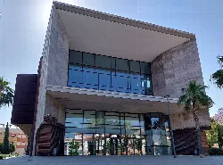 Modern theatre facade with large windows and concrete structure.