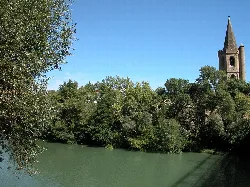 Aragon River with trees and a church in Sangüesa.
