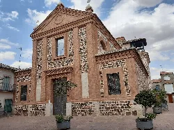 Facade of a church with bricks and stone in Calzada de Calatrava.