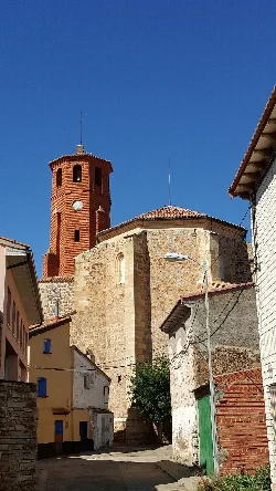 Iglesia de San Pedro y San Pablo en Used, Zaragoza, con torre de ladrillo y estructura de piedra.