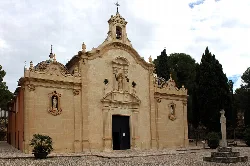 Fachada del santuario con detalles barrocos y crucifijo en el patio.