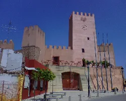 Torre y murallas del castillo en Bétera, con cielo azul.