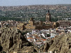 Moorish castle and cathedral in Guadix with white houses and plateau landscape.