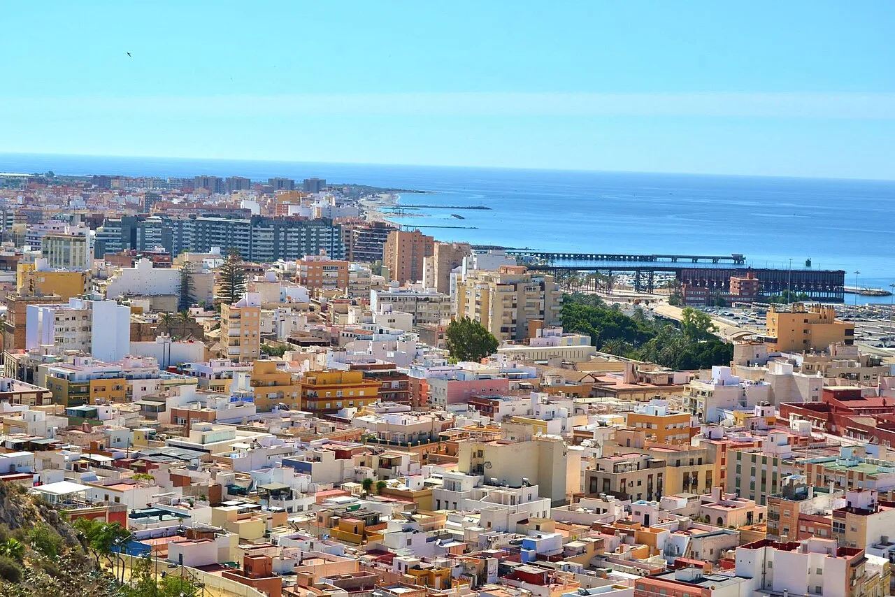 Vista de la ciudad de Almería con edificios y mar en el fondo.