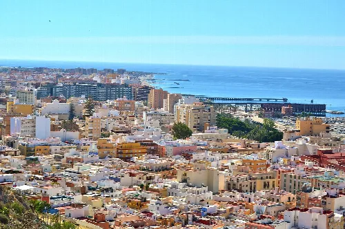 Vista de la ciudad de Almería con edificios y mar en el fondo.