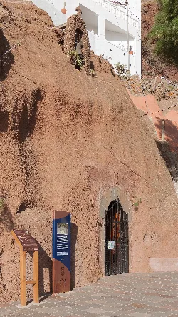 Kleine Kapellenfassade in den Felsen gebaut mit einer schwarzen Gittertür.