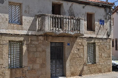 Altes Haus mit Steingeländer und vergitterten Fenstern in Peraleda de San Román.
