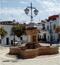 Brick fountain with a lamp on top in the square.