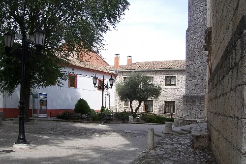 Plaza con árboles, farolas y edificios en Aldeamayor de San Martín.