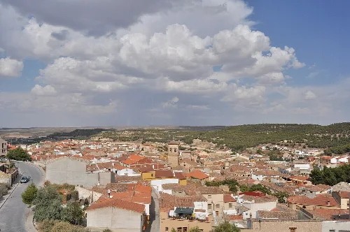 Vista de tejados, iglesia y cielo con nubes en Chinchilla de Montearagón.