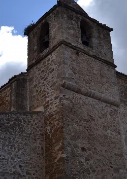 Torre de piedra con ventanas en la parte superior en Ibahernando.