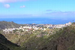 View of a town in a valley with the sea in the background.