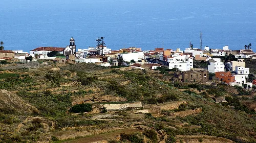 View of white houses in Arico with the blue sea behind.
