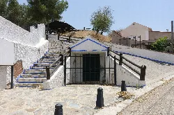Stairs and a metal gate at the entrance of the ethnographic museum of El Romeral.