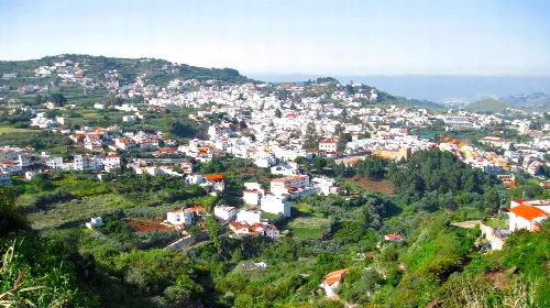 Panoramablick auf Teror mit weißen Häusern und Vegetation auf Hügeln.